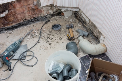 Canalisations déposées et outils dans une pièce d’eau en travaux.