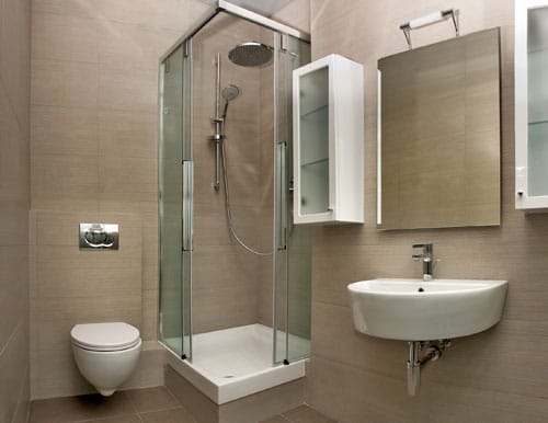 Salle de bains avec douche vitrée, lavabo mural et WC suspendu.